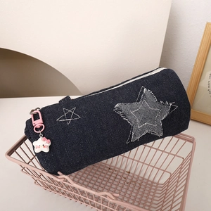 Detailed macro view of denim star pencil case with cute pink cartoon cat charm