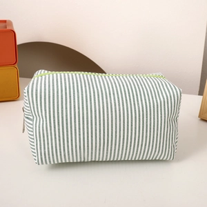 Detail of green and white striped canvas pencil case with a bright green zipper closure