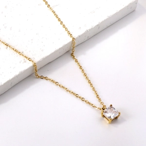 Gros plan du pendentif en zircon carré plaqué or 18 carats sur socle en marbre blanc