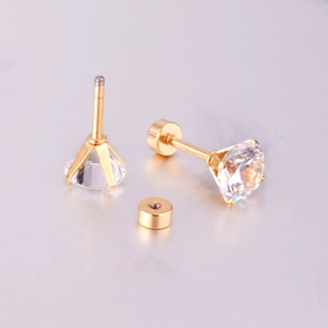 Four-prong round white cubic zirconia stud earrings with gold screw backs on a grey surface
