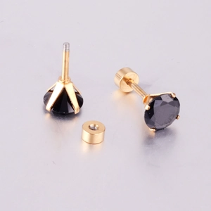 Macro detail of screw-back earrings featuring black round stone in gold-plated four-prong setting
