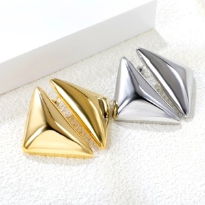 Close-up of minimalist gold and silver triangle stud earrings in polished stainless steel