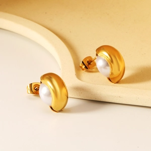 Boucles d'oreilles clous dorées en forme de C avec perles blanches sur fond sobre