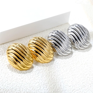 Detailed macro view of irregular textured gold and silver stainless steel stud earrings