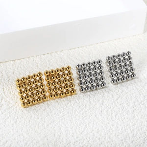 Close-up of square grid stud earrings with 25 polished metal beads in gold and silver