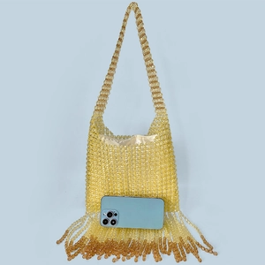 Detail of yellow beaded bag with dense fringe and smartphone for size reference