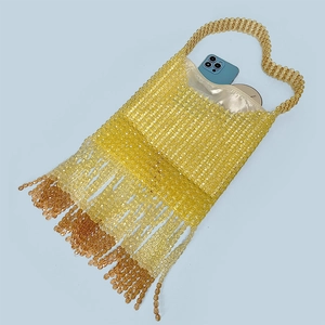Detail view of handmade beaded bag with amber tassels and champagne satin lining