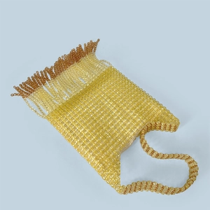 Detailed view of handmade amber and yellow beaded bag with fringe tassels and woven handle