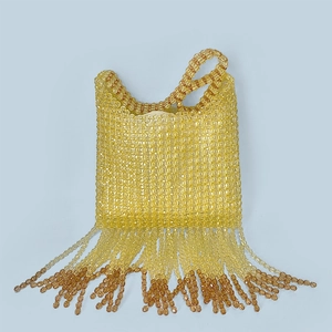 Detailed view of handmade beaded tassel bag with yellow and amber gradient beads