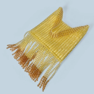 Close-up of handmade amber beaded handbag with long flowing fringe design detail