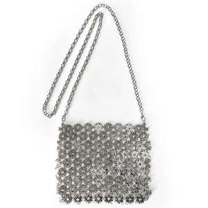 Detailed view of silver daisy metal disc patchwork bag with fine chain strap