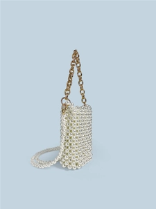 Handmade white pearl beaded mini crossbody bag with gold chain and strap on blue background
