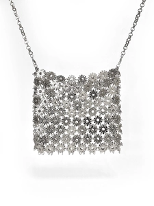 Macro detail of silver floral interlocking metal chain mesh on luxury crossbody bag