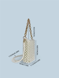 Handmade pearl beaded square mini bag with golden chain and long strap on blue background