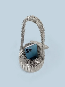 Detail of silver sequin bag showing interior capacity with a smartphone inside