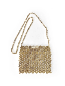 Detail showing intricate gold metal daisy floral pattern on woman's crossbody phone bag