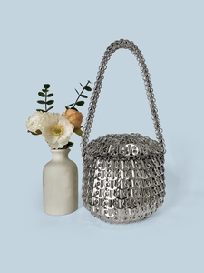 Close-up of handmade silver sequin bag with industrial metal ring weave and chain handle