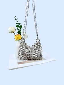 Detail of silver metallic woven texture and chain strap on stylish sequin handbag
