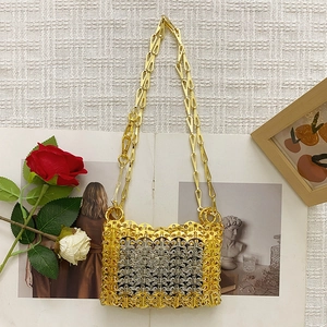 Detail of handmade metallic chainmail bag featuring gold and silver woven ring patterns