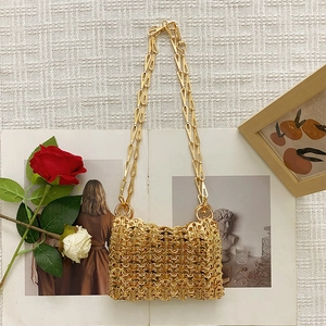 Macro shot of gold woven metal texture and chain strap on a designer shoulder bag