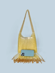 Amber beaded fringe shoulder bag with handmade tassels and a blue phone for scale