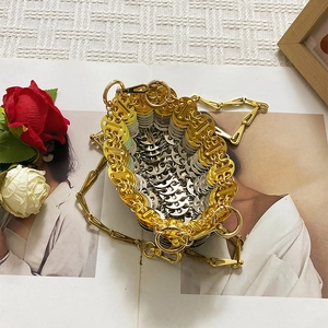Detail of handmade silver and gold metal ring weave bucket bag with chain strap