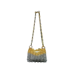 Macro detail of handmade metallic sequin bag featuring gold and silver chainmail design