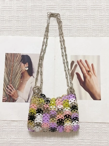 Detail of colorful sequins connected by silver metal rings on a handmade chain bag