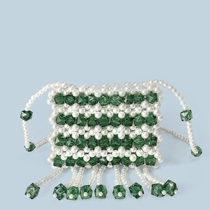 Detail of handmade beaded mini bag with green crystals, white pearls and hanging tassels