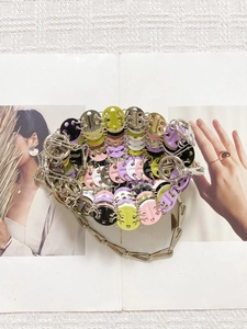 Close-up of colorful sequins linked by silver metal rings on a designer chain bag