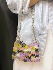 Macro detail of handmade colorful sequins and silver chain strap on a stylish shoulder bag