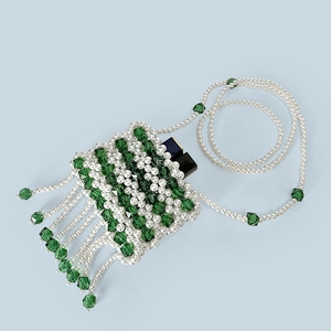 Detail of beaded mini bag with white pearls, green crystals and decorative tassels