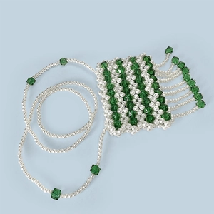Close-up of handmade pearl and green crystal bead mini bag with tassel details