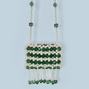 Detail of handmade beaded mini bag with green crystal stripes and pearl fringes