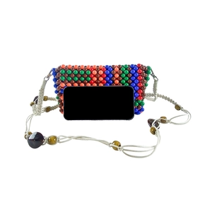 Detail view of colorful handmade beaded crossbody bag with size comparison to a smartphone