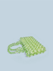 Détail de sac à main fait main en perles de cristal vert avec des accents élégants