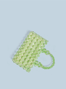 Détail de perles de cristal vert et perles blanches sur un sac à main fait main
