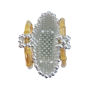 Macro view of silver beaded handbag with natural bamboo handle and woven texture