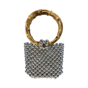 Macro detail of silver beads and natural bamboo handle on a beaded handbag