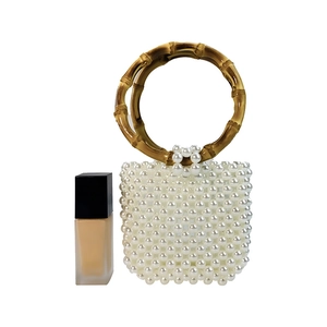 Detail of white beaded handbag with vintage amber-colored resin bamboo handle