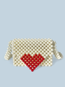 Sac à main artisanal en perles blanches avec motif cœur rouge et poignée ronde