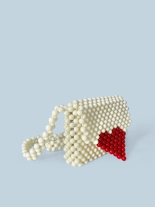 Sac à main fait main en perles crème avec un motif de cœur rouge sur fond bleu clair