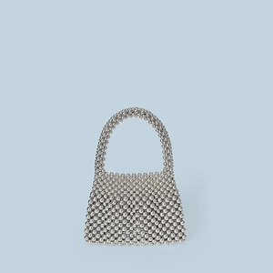 Détail montrant la texture perlée argentée tissée à la main d'un sac à main de luxe