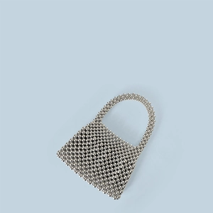 Vue à plat macro d'un mini sac à main argenté perlé avec poignée anneau et éclat