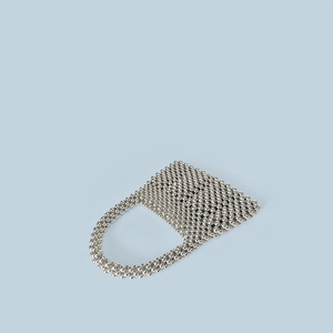 Détail d'un sac à main artisanal en perles argentées avec poignées circulaires