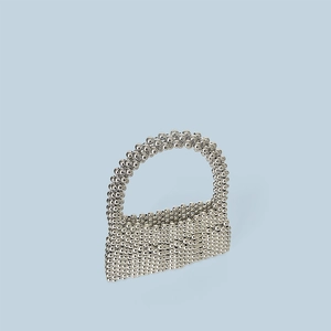Détail du sac à main en perles argentées avec texture tissée et poignée ronde