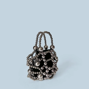 Macro shot of gunmetal beaded handbag with metallic mesh texture and black lining