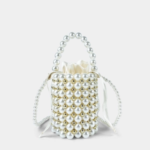 Detailed close-up of handmade pearl bucket bag with gold beads and satin drawstring liner