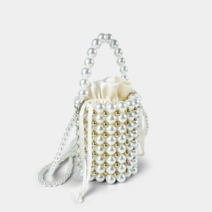 Detail of beaded pearl bucket bag with gold accents and a satin drawstring liner