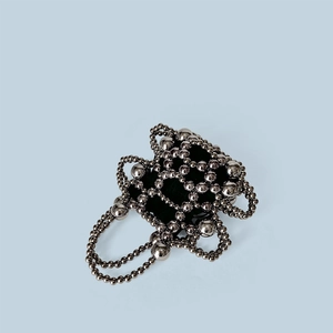 Detailed view of hand-woven dark gray metallic beads and black inner lining fabric